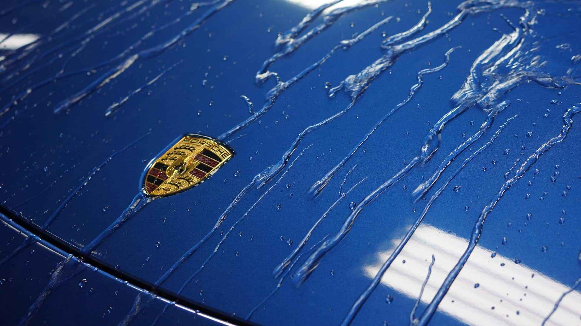 Water sheeting off a ceramic coated blue Porsche hood
