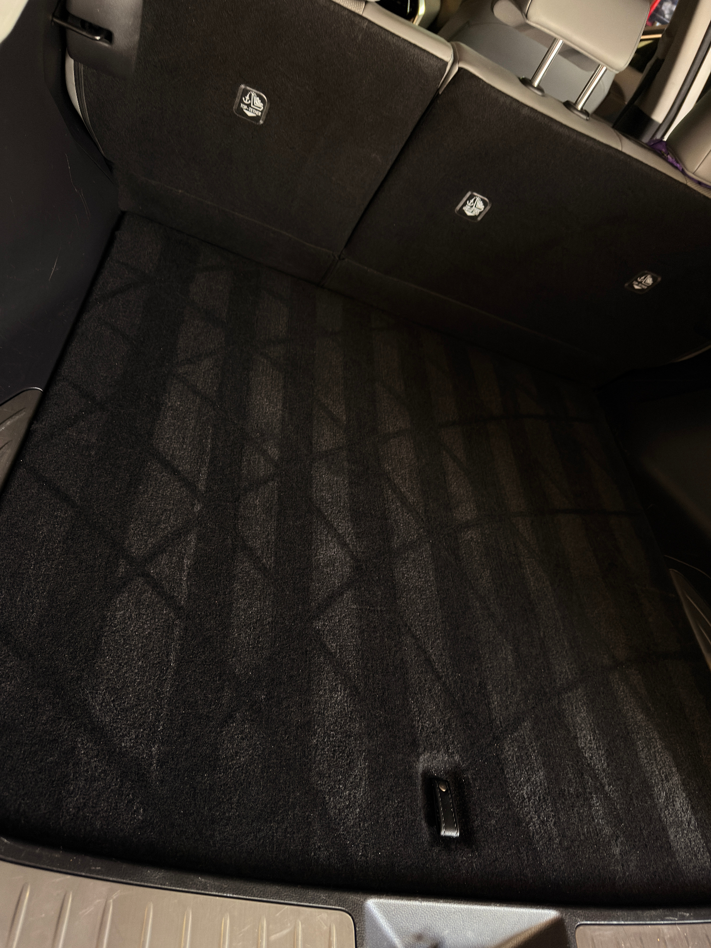 Freshly vacuumed black trunk carpet with clean lines